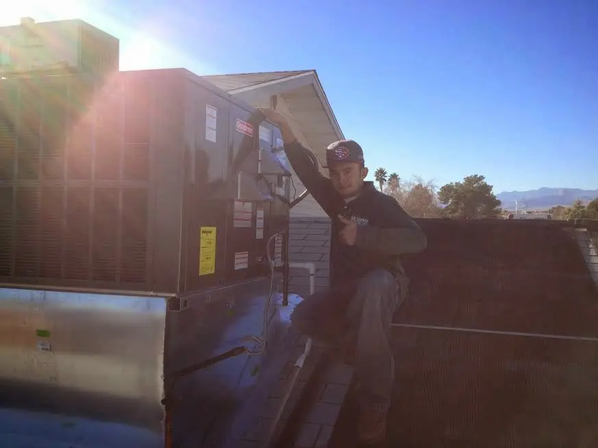 HVAC technician performing Air Duct Repair on a rooftop unit in Shorewood